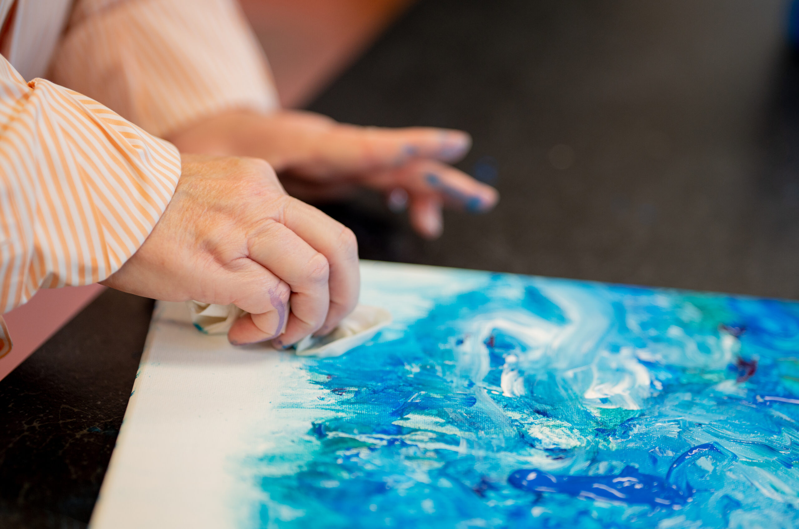 Arts recreation class image where a participant is painting on a canvas