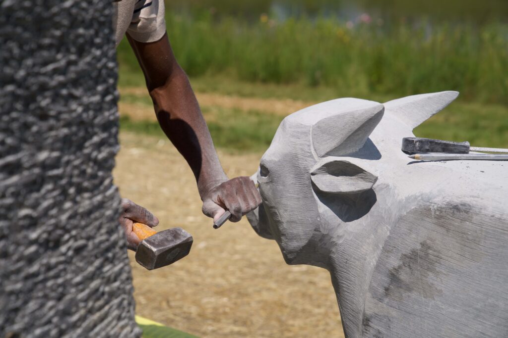 Artist, Dominic Benhura, sculpting the Bison & Calf. 