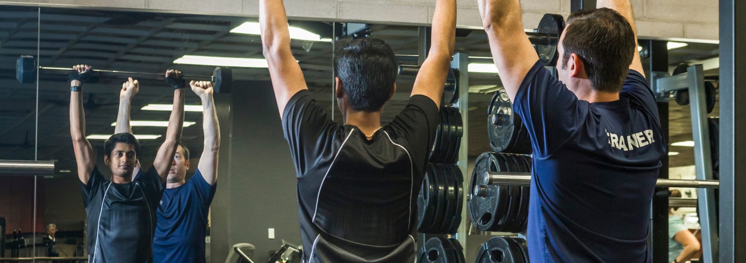 Personal trainer training with a client in the Fitness Center at the Monon Community Center.