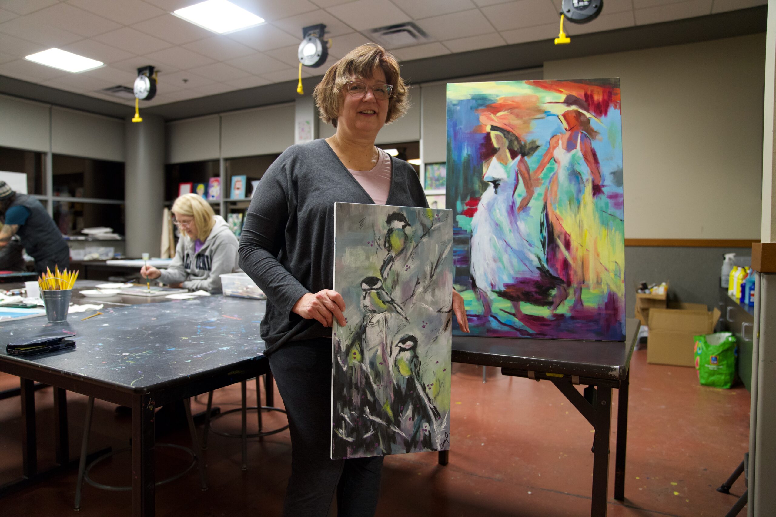 Cathy O holding her artwork that she made in art classes at the Monon Community Center